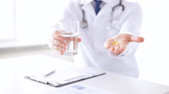 male doctor hands with pills and glass of water