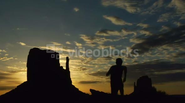 Silhouette Of Man Running With Monument Valley Sunrise