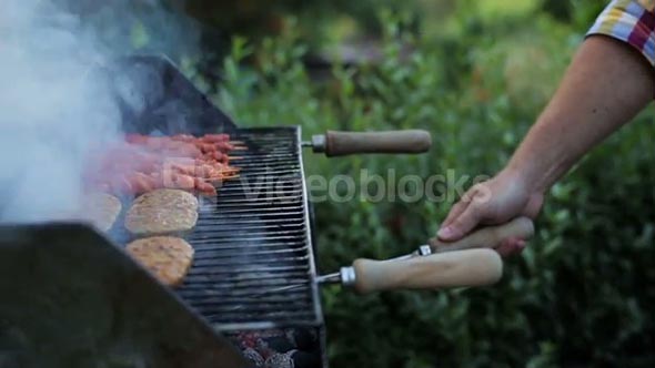 man's hands prepring food on grill