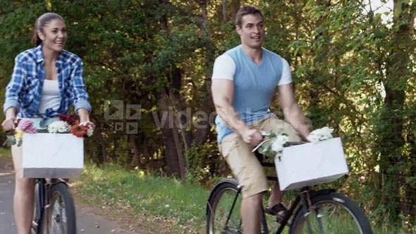 Happy couple cycling on a country road bicycle lane, steadicam shot.