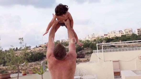 Father throw his son over blue sky, slow motion shot at 240fps