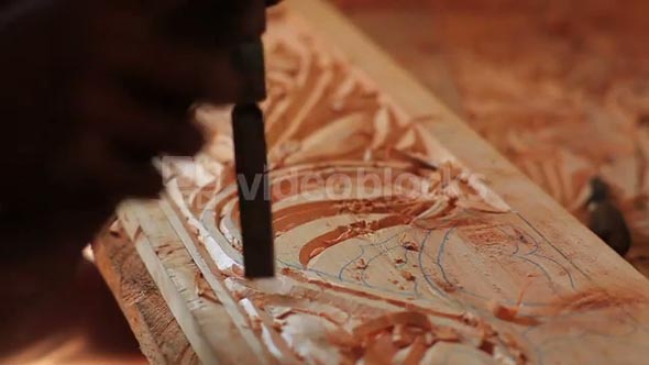 Closeup of Man Chiseling Designs Out of Wood
