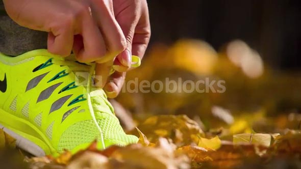Running shoes. Barefoot running shoes closeup. Female athlete tying laces for jogging on road in minimalistic barefoot running shoes. Runner getting ready for training. Sport lifestyle. Slow motion.