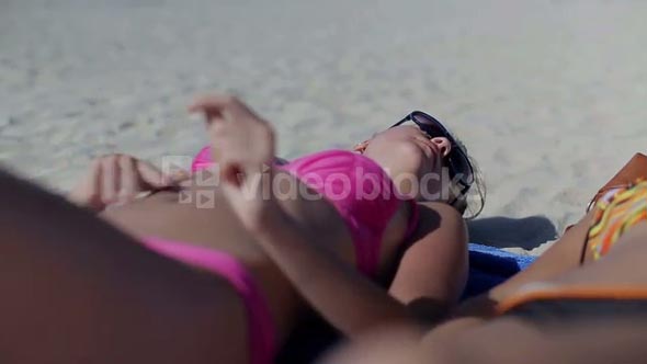 Sexy women lying on the beach and sunbathing
