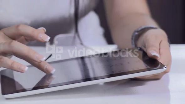 Attractive brunette woman using tablet computer retail internet surfing.