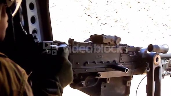 Chinook door gunner fires his machine gun