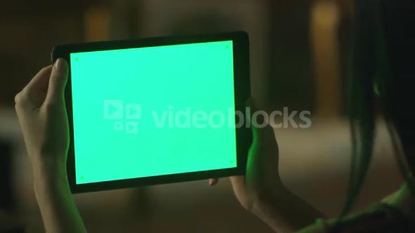 Black Hair Teen Girl is Holding Tablet with Green Screen in Landscape Mode at Evening Time. Casual Lifestyle.