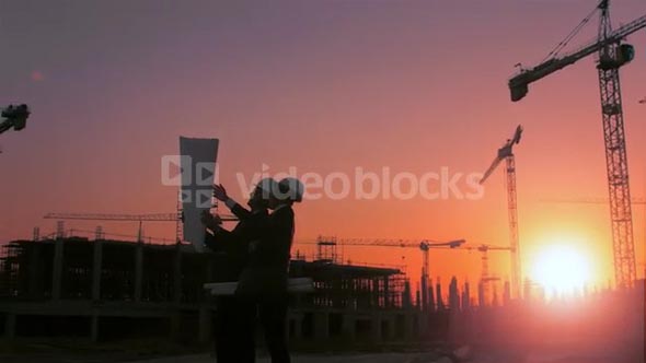 Steadicam shot of skyline and cranes with construction workers