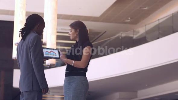 Static shot showing a man and a woman using digital technology in a business environment